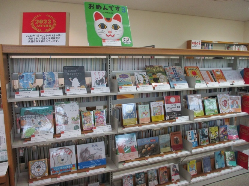 4段の書架に展示資料の表紙を見せて並べた様子