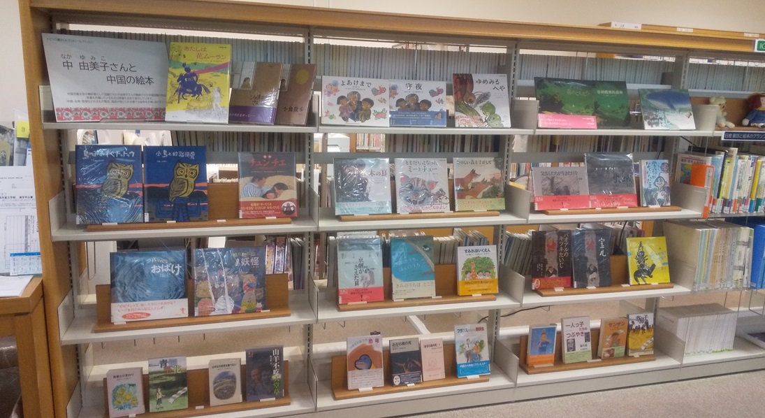4段の書架に展示資料の表紙を見せて並べた様子