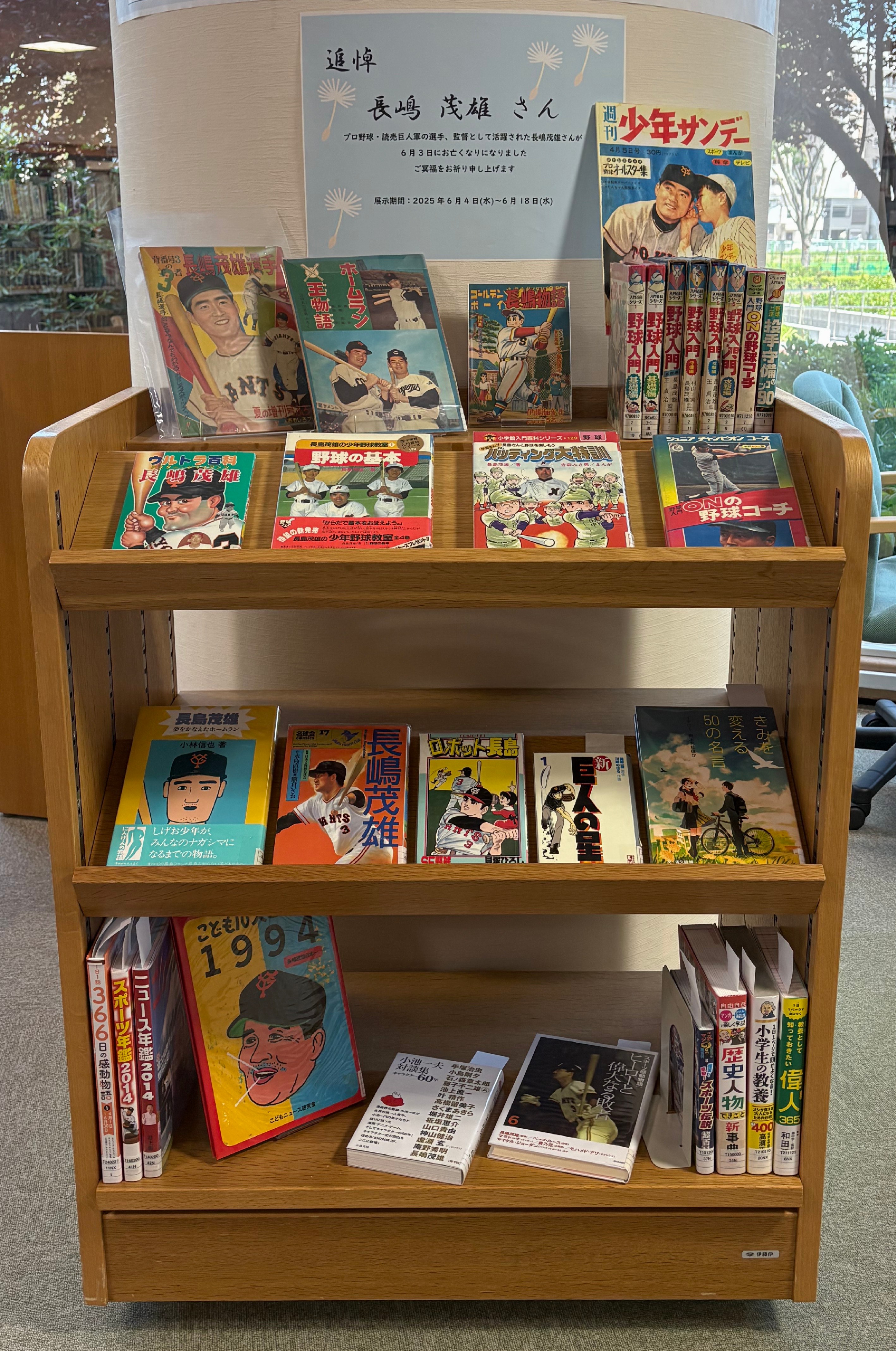 三段の棚に長嶋茂雄さんの著書や関連資料の表紙を見せて並べた展示の様子