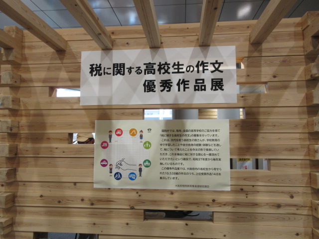 昨年度の展示の様子 税に関する高校生の作文優秀作品展と書かれたポスターと説明のポスターが掲示されている