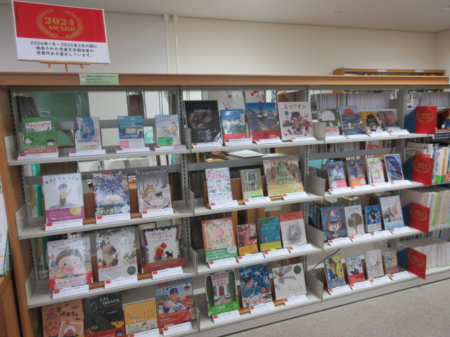 4段の書架に展示資料の表紙を見せて並べた様子