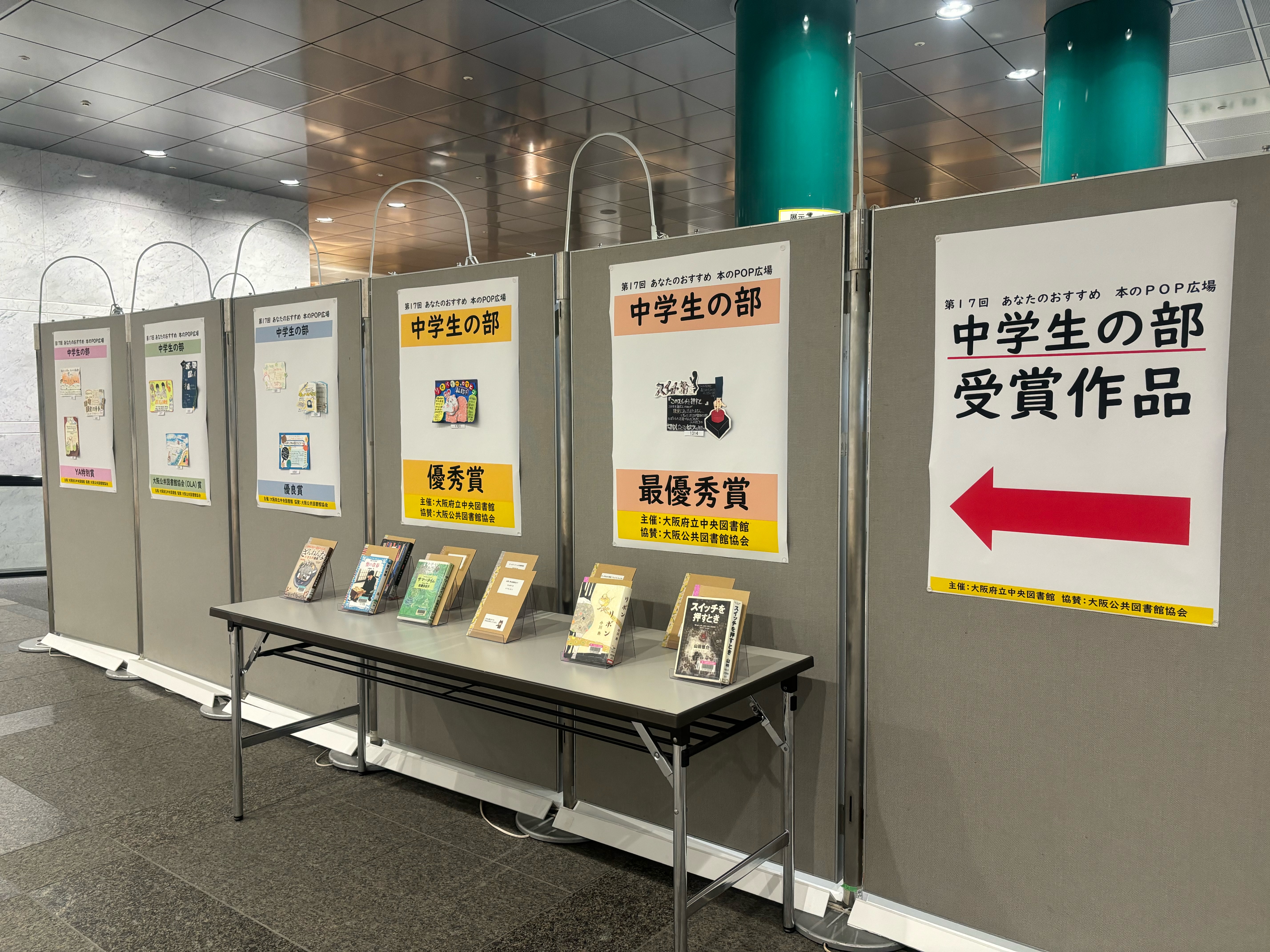 中学生の部:並んだボードの右から左奥にかけて、高校生の部受賞作品のポスターから始まり、ボードに受賞作のPOP、その前の机に本が展示されている風景写真