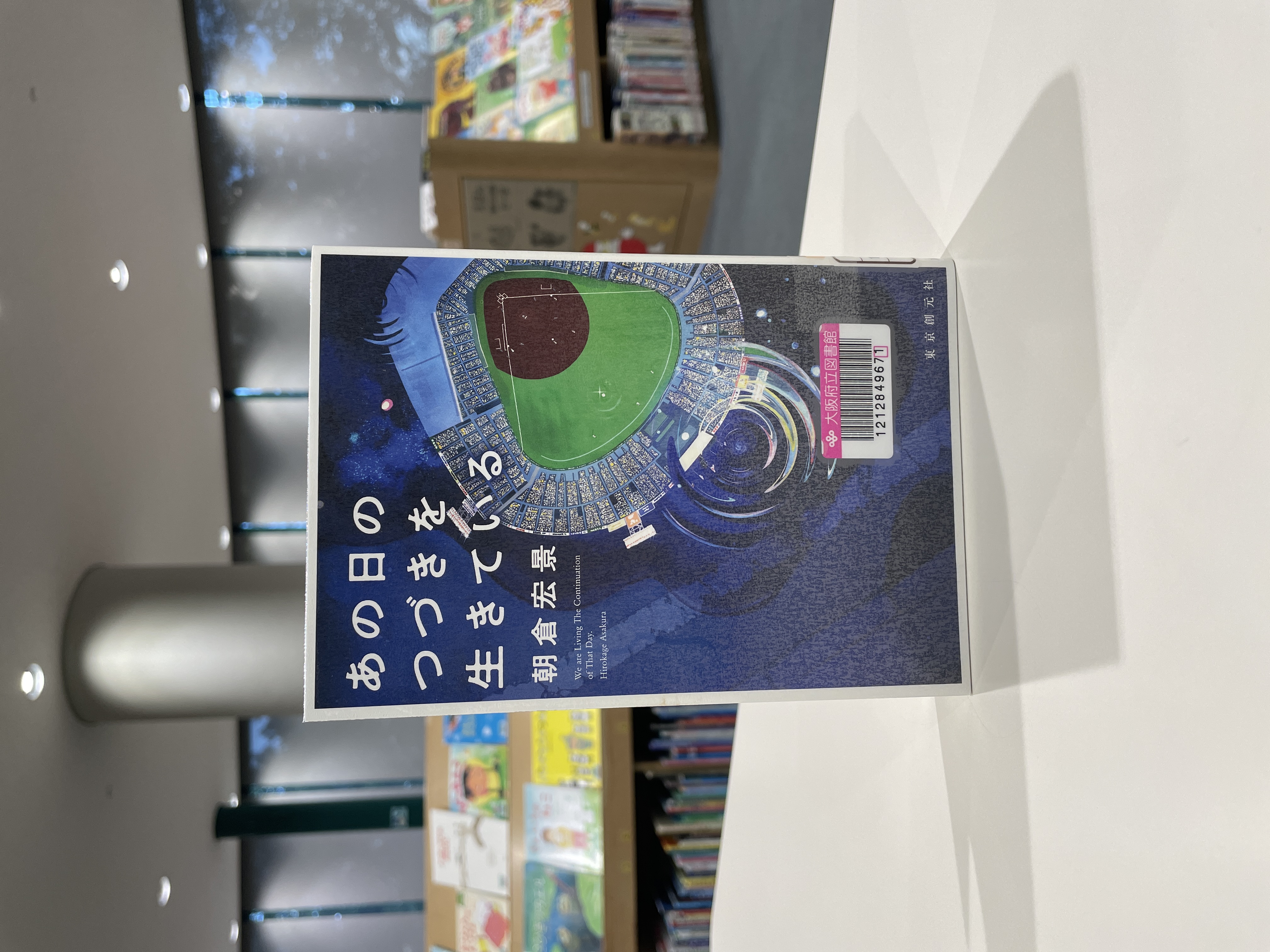 『あの日のつづきを生きている』の表紙画像。甲子園を上から見たイラストと水たまりが描かれている。
