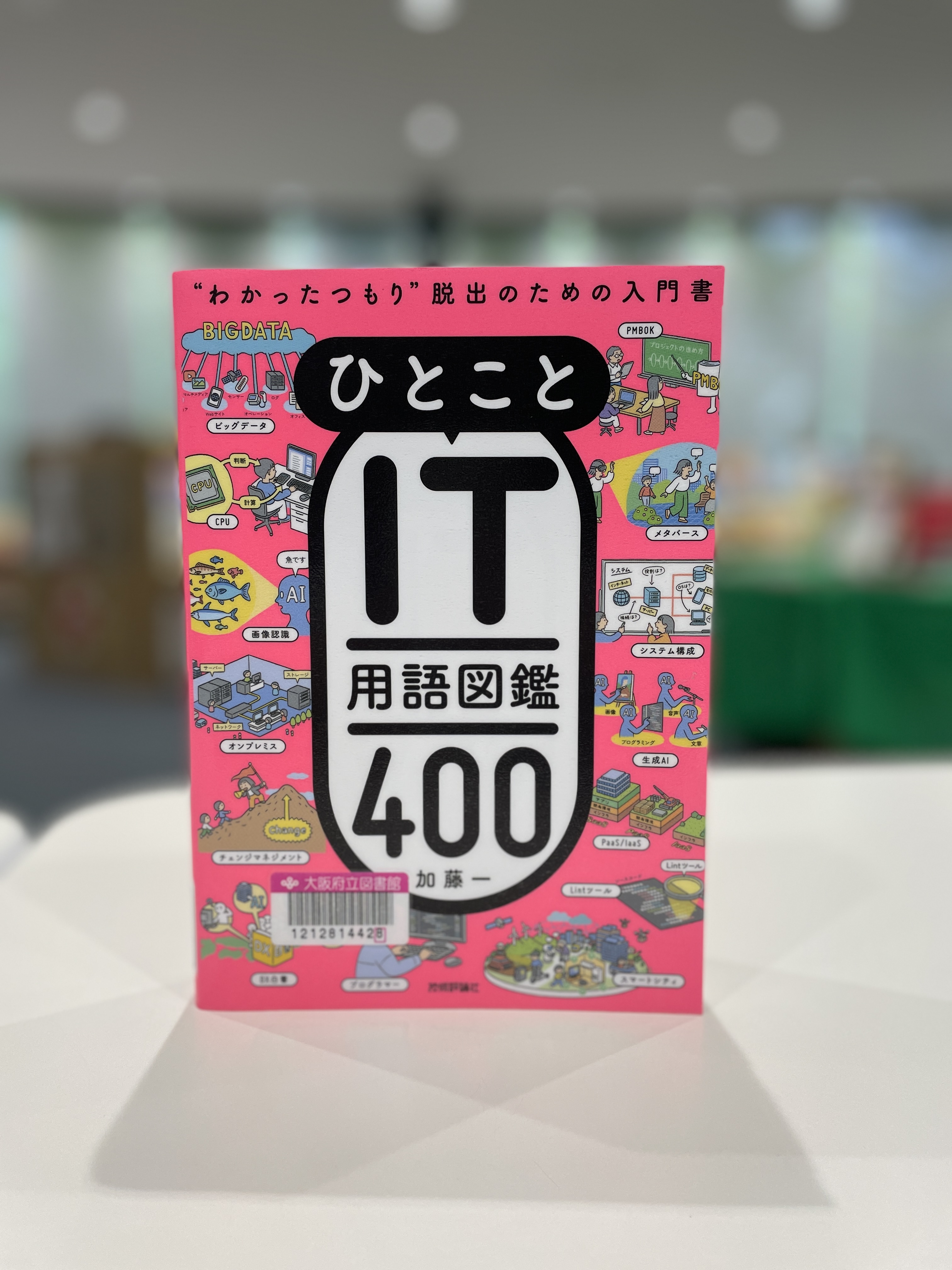 『ひとことIT用語図鑑400：“わかったつもり”脱出のための入門書』 の表紙画像。蛍光ピンク色の表紙にタイトルと様々なIT用語をイメージしたイラストが描かれている。