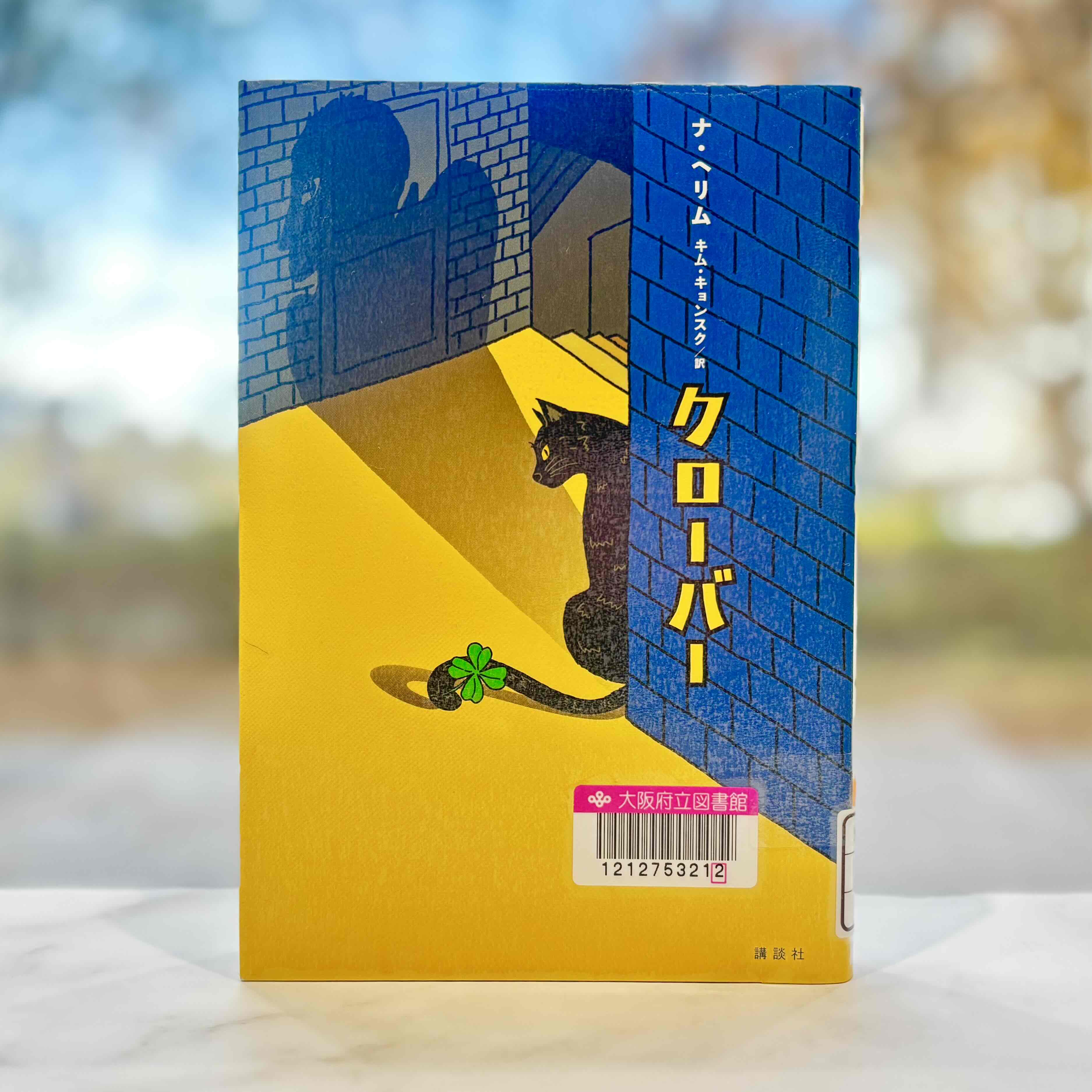 『クローバー Clover』の表紙画像。レンガの壁に隠れる猫の影が悪魔になっているイラスト。