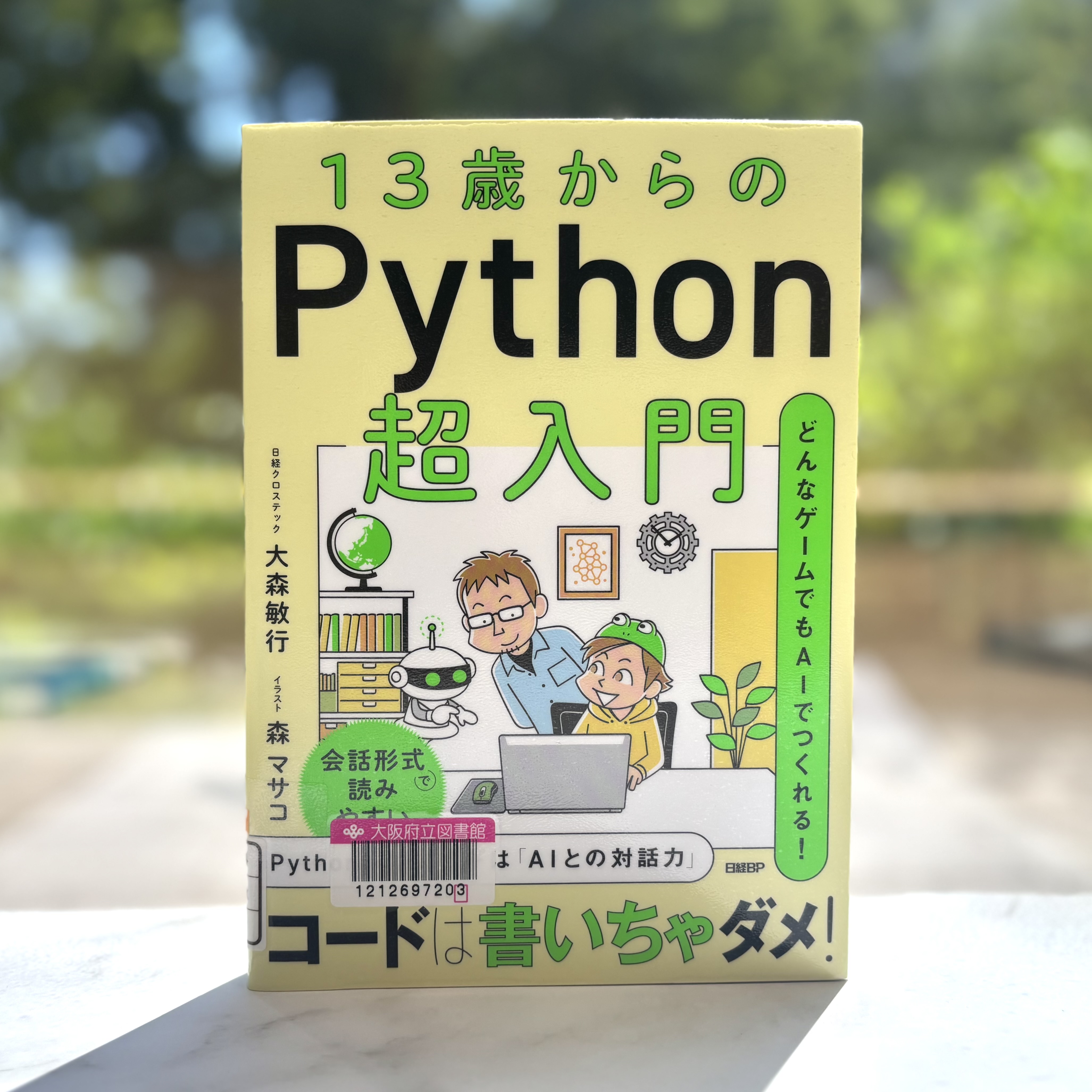 『13歳からのPython超入門：どんなゲームでもAIでつくれる!』の表紙画像。黄色の背景に男の子と男性とロボットがノートパソコンをのぞき込んでいるイラスト。