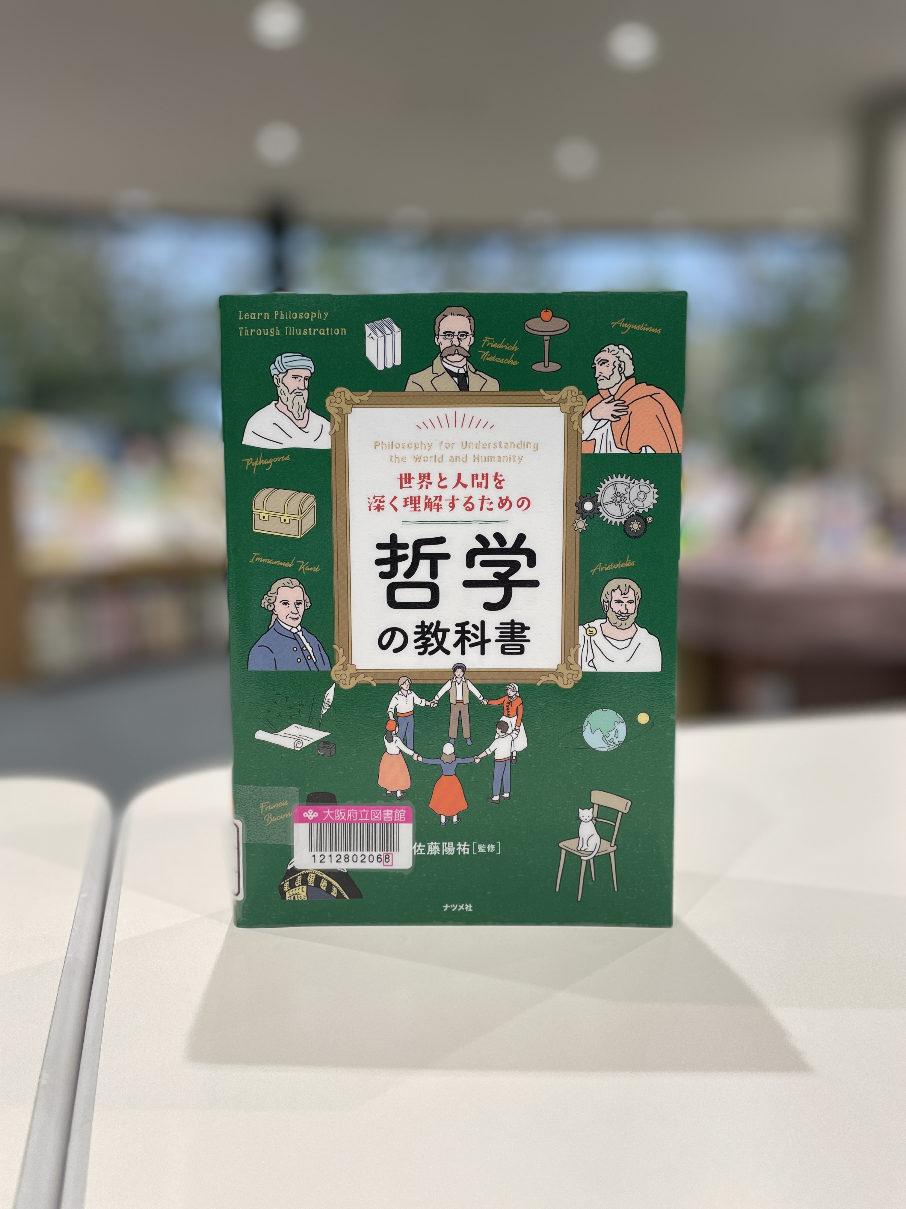 『世界と人間を深く理解するための哲学の教科書』の表紙画像。緑色の表紙に様々な哲学者のイラスト等が描かれている。