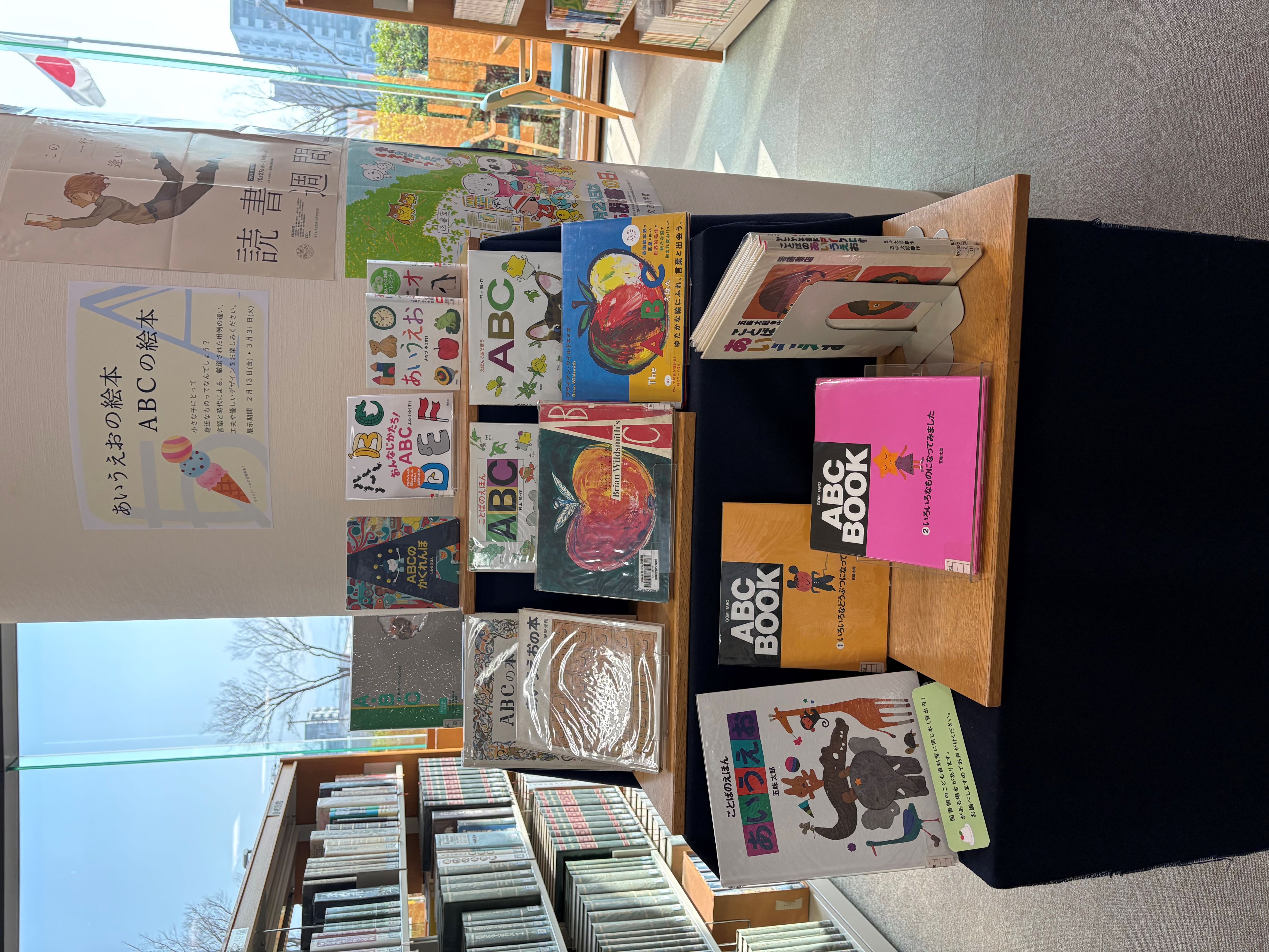 「あいうえおの絵本ABCの絵本」の展示の様子。3段の棚に『ことばのえほんあいうえお』などの本が表紙を見せて並んでいる。