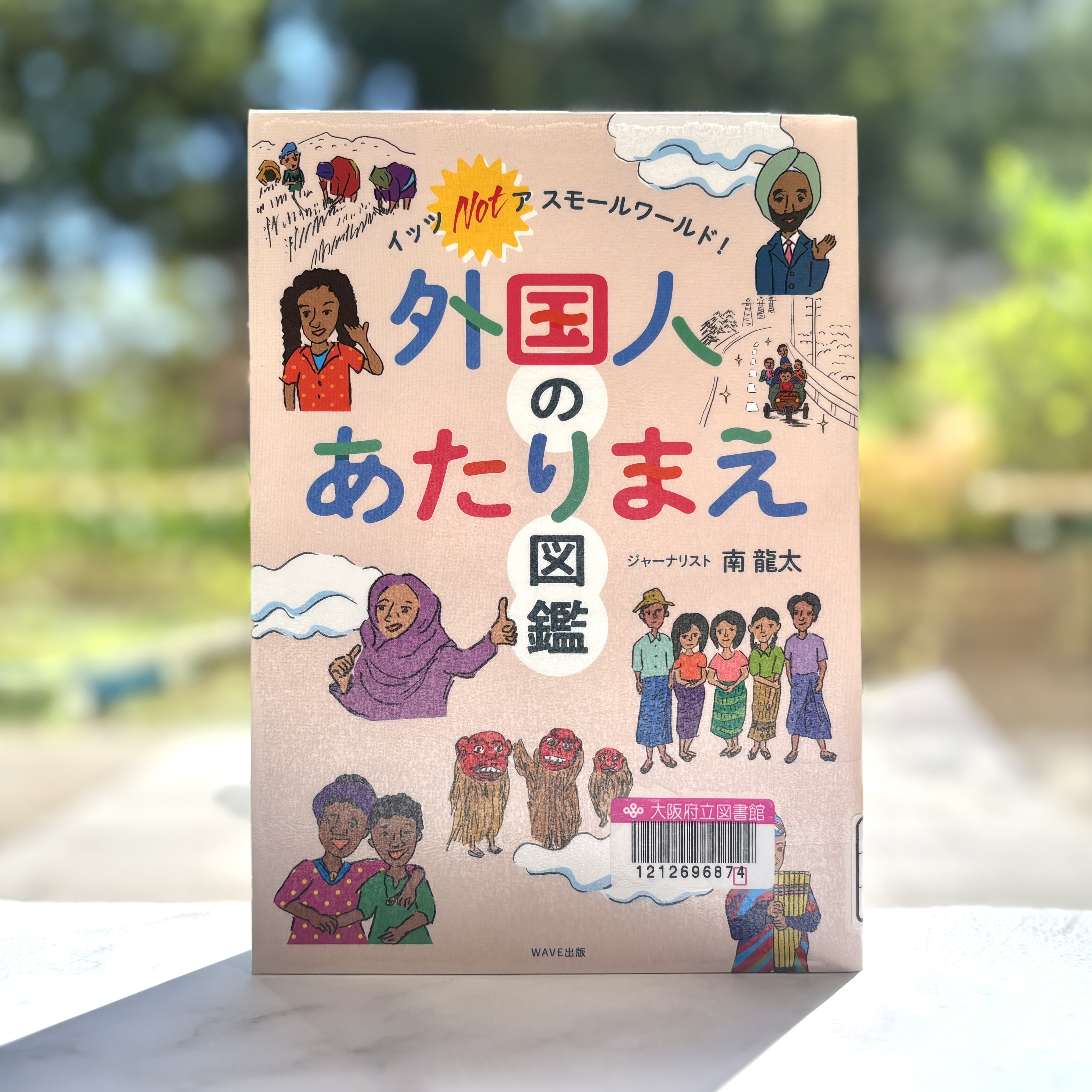 『外国人のあたりまえ図鑑：イッツNotア スモールワールド!』の表紙画像。いろんな国の人々が描かれたイラストの真ん中にタイトルが書かれている。