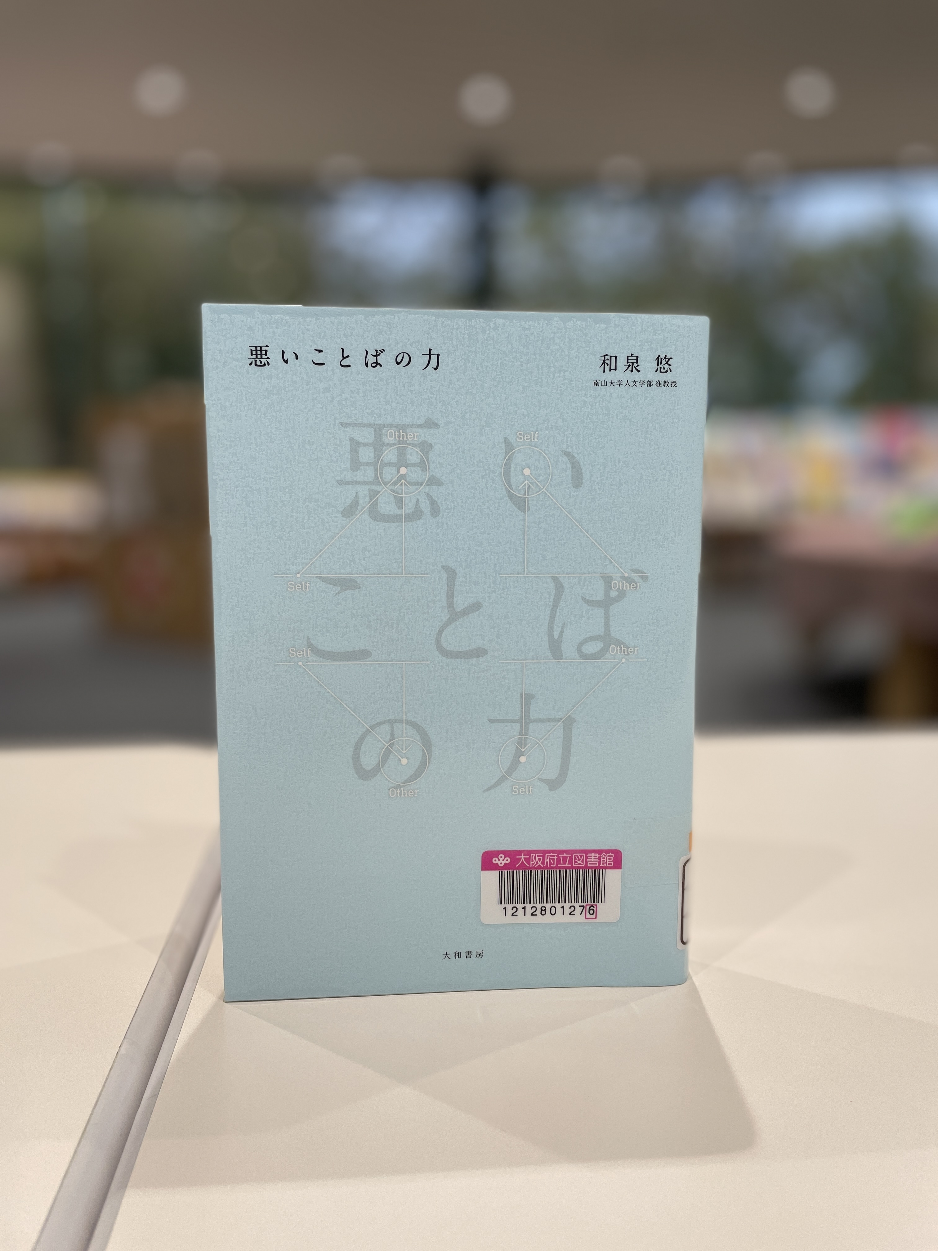 『悪いことばのちから』の表紙画像。水色の表紙にタイトルと直線や円で幾何学模様が描かれている。