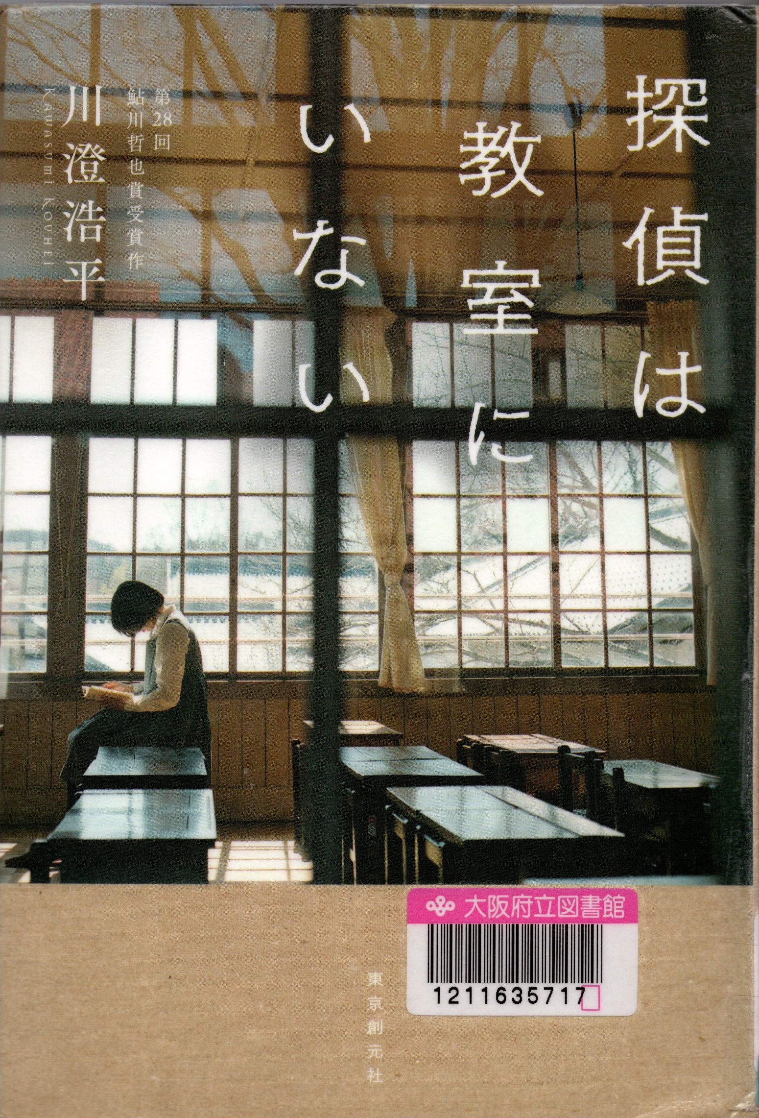 『探偵は教室にいない』の表紙。教室の机の上に本を読みながら座る女性が描かれている。
