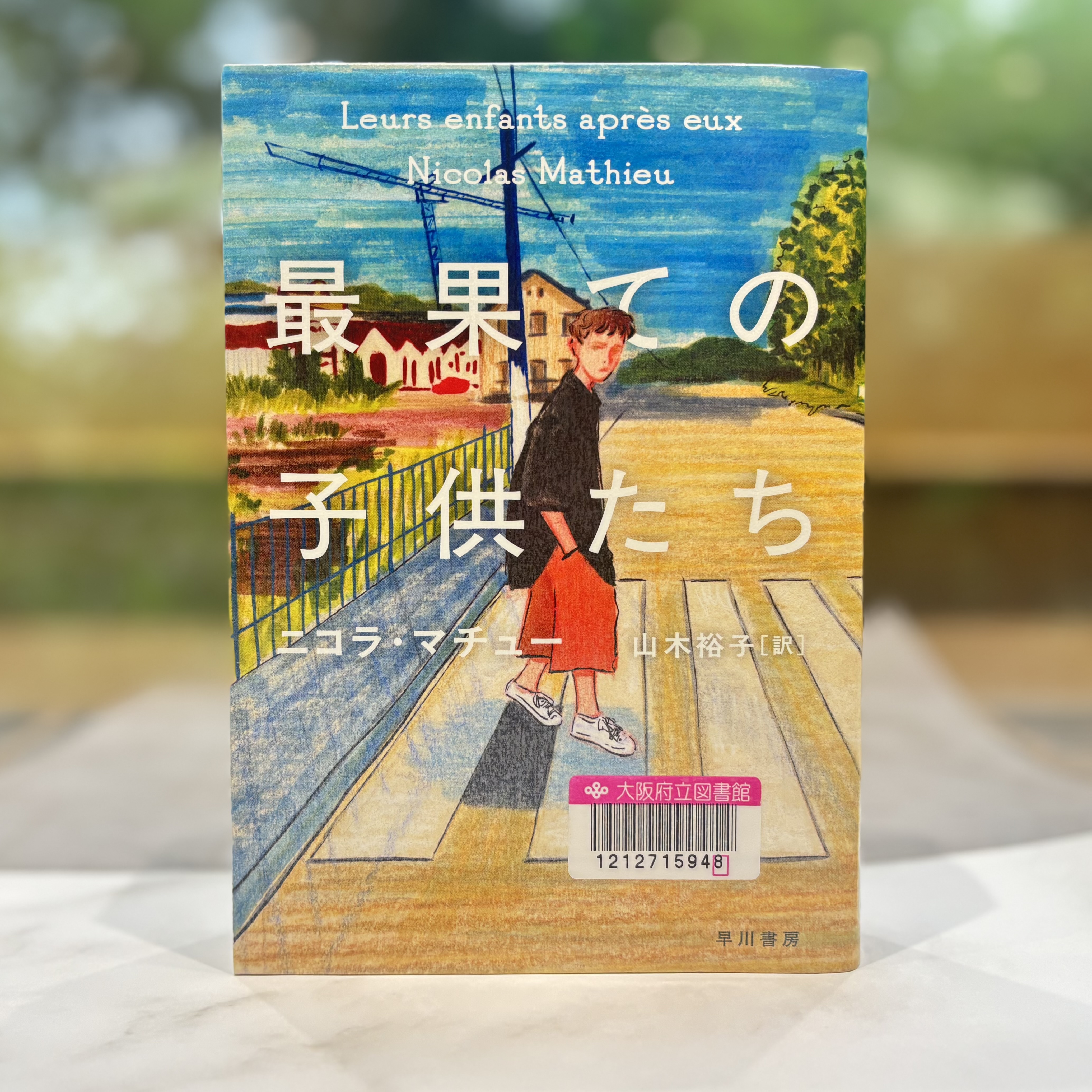 『最果ての子供たち』の表紙画像。男の子が住宅街にある横断歩道を渡っているイラストが描かれている。