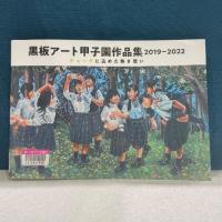 緑の布を背景に『黒板アート甲子園作品集　2019-2022　チョークに込めた熱き想い』の表紙