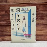 木の板を背景に『涙を食べて生きた日々　摂食障害-体重28.4kgからの生還』の表紙