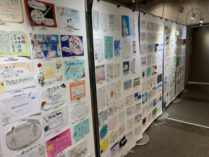 1枚の大きな紙に40ほどのPOP作品を張り付けた大きな紙をボードに貼って掲示している
