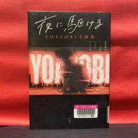 赤い壁紙を背景に『夜に駆ける　YOASOBI小説集』の表紙が撮影されている