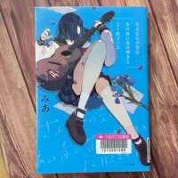 木の板を背景に『さよならの空はあの青い花の輝きとよく似ていた』の表紙